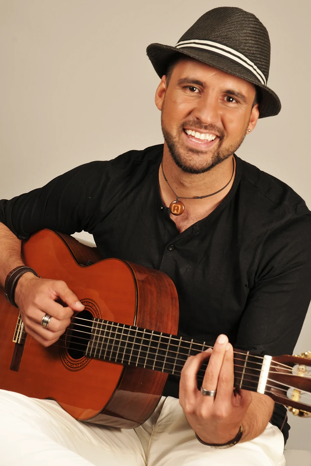 Alessandro Galas lächelt mit akustischer Gitarre