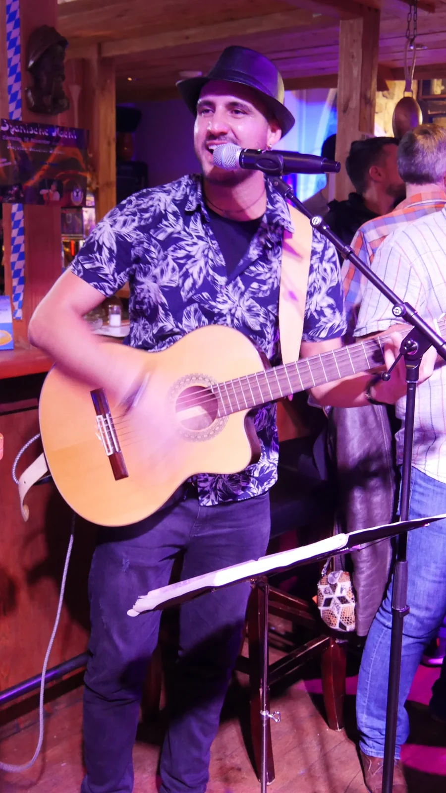 Alessandro Galas lächelt beim Singen mit Gitarre